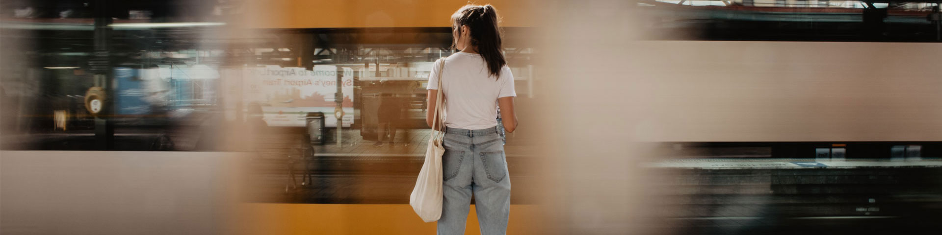 Woman standing on a train platform as a train goes by