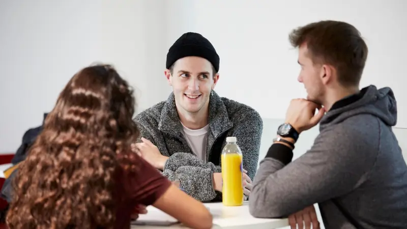Students sat at a table talking to each other
