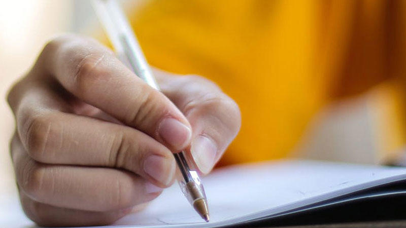 a close up of a hand writing with a pen