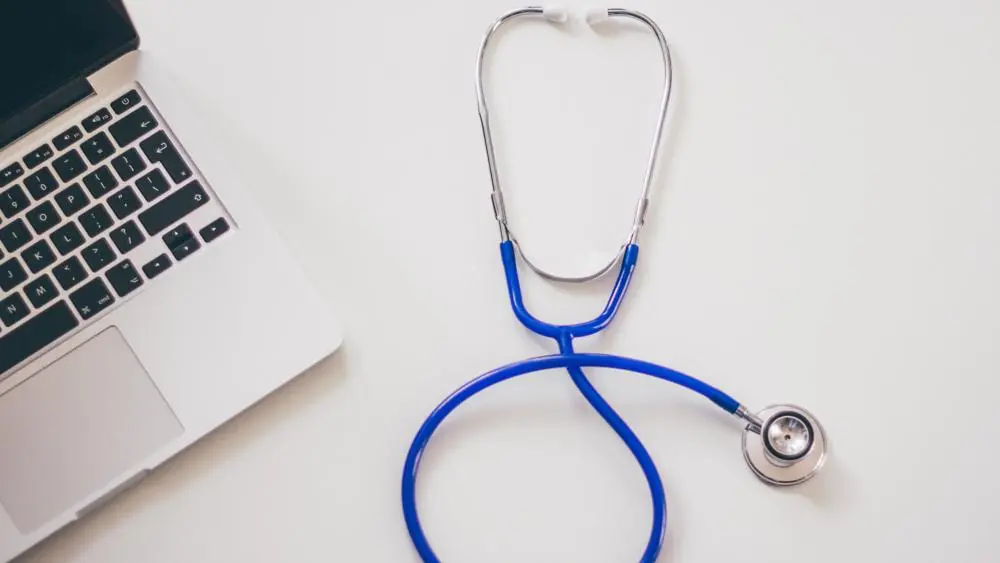 laptop and stethoscope on a desk