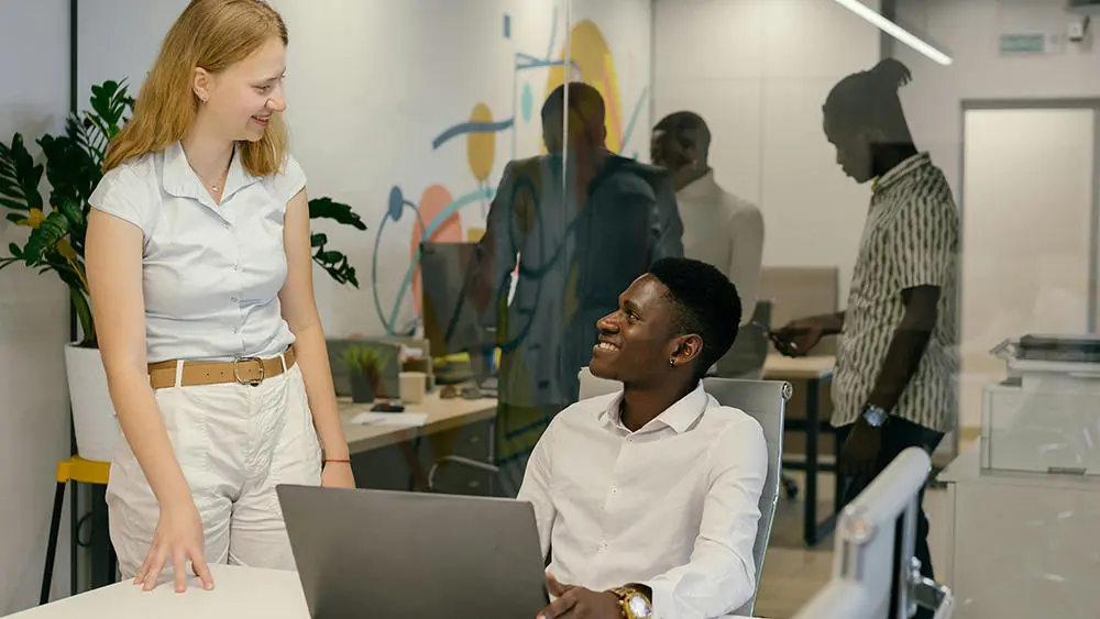 A man and women talking to each other at desk