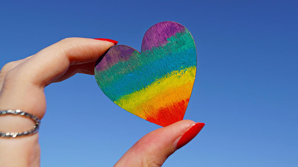 rainbow pride on heart held by lady