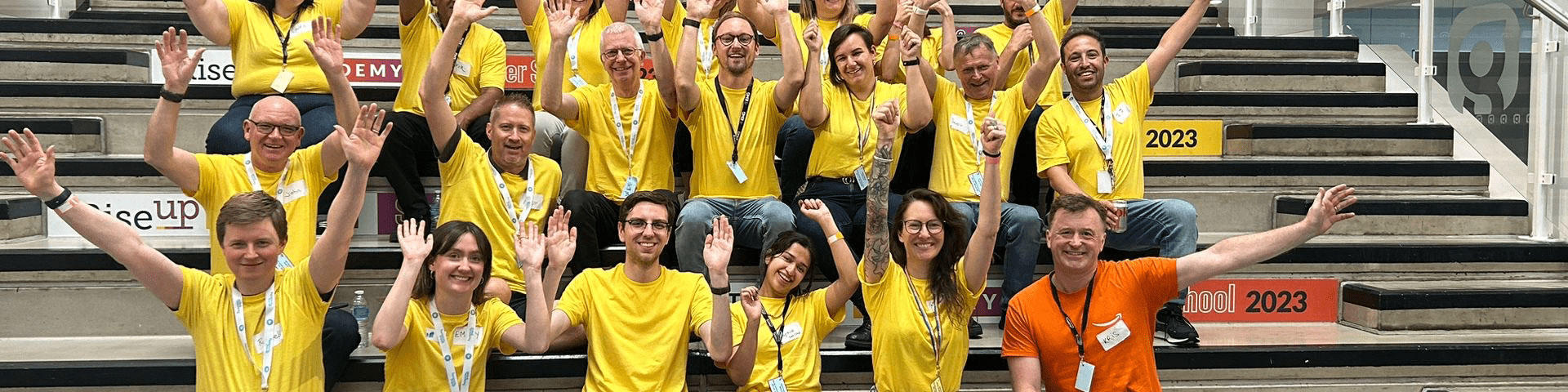 A group of men and women sit together smiling and cheering.