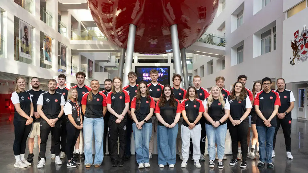 Student athletes in a group photo under the pod