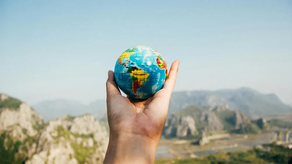 A person holding a globe in their hand