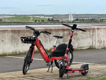 Voi e-scooter and bike parked on a street